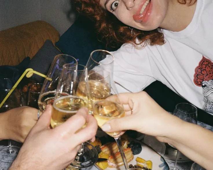 Glasses clinking over a table at a birthday dinner